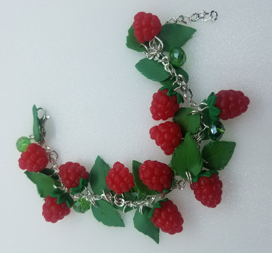 Polymer clay raspberry bracelet shown open with silver chain, lobster clasp, leaf charms and green crystals